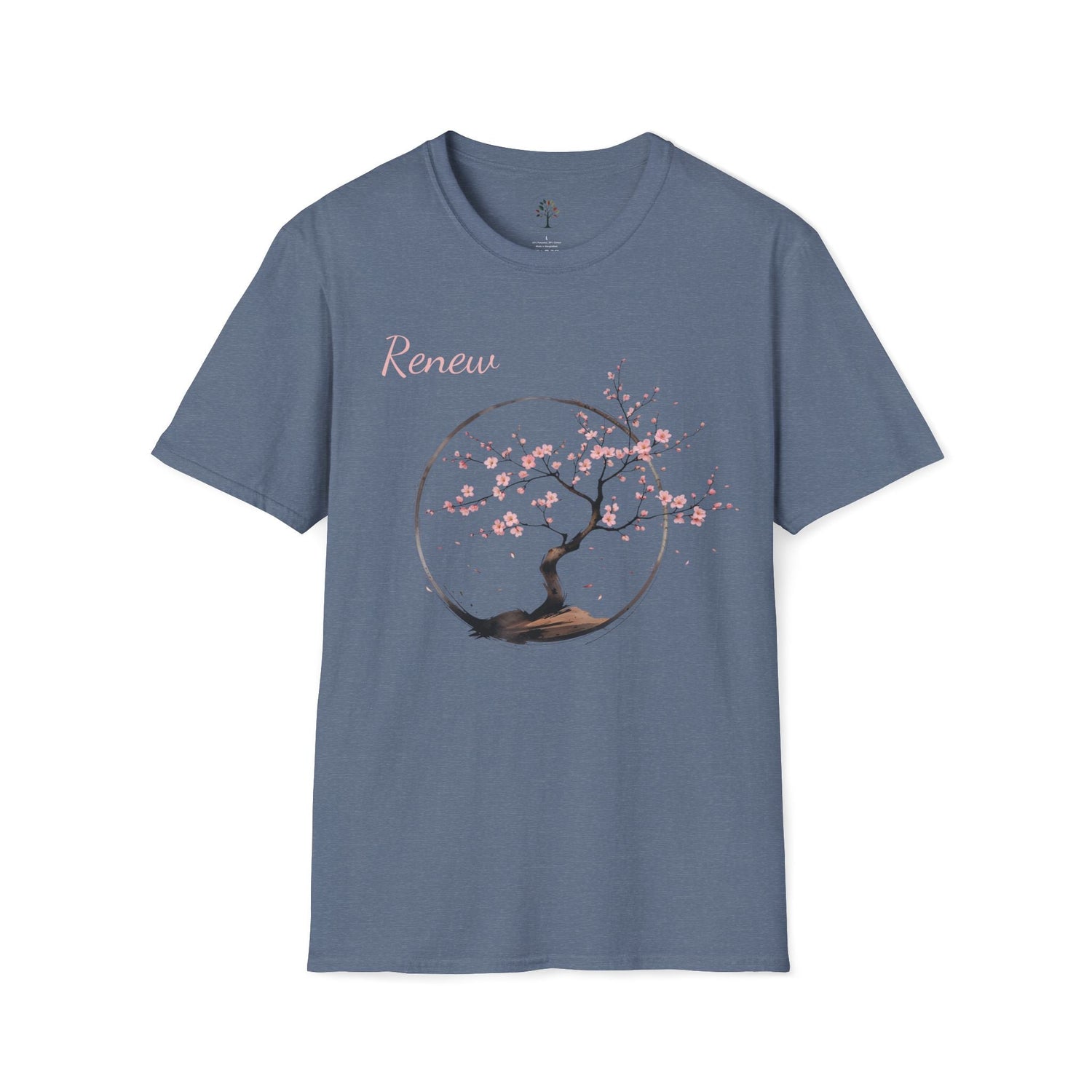 Renew Tee in Heather Indigo — cherry blossom tree in full bloom inside a brushstroke circle, soft pink flowers and falling petals, warm earth tones against deep blue-grey fabric, "Renew" in delicate script above the illustration.